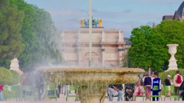 Tuileries Garden, Paris, Fransa, 30.05.2025. İnsanlar parkta yürüyor ve güzel bir çeşme işliyor..