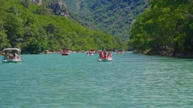 People on boats, catamarans and canoes explore Verdon Gorge at summer. France.