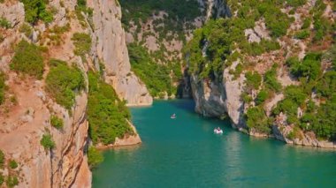People on boats, catamarans and canoes explore Verdon Gorge at summer. France.