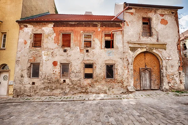 古い建物の修理が必要な大きな木製のドアの入り口のそばにスロバキアのブラチスラバの旧市街 旧市街 の石畳の通り — ストック写真