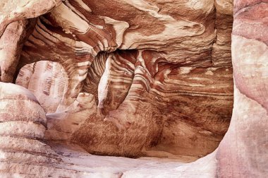 A view inside one of the burial chambers of Petra that shows the beautiful red rock striations of the sandstone in that part of Jordan. clipart