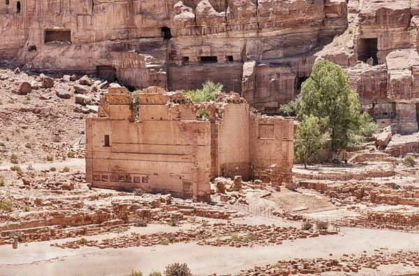 ヨルダンのペトラの崖壁の墓のいくつかの下ローマ列柱の終わりに Dushares の神殿の遺跡に立つ — ストック写真