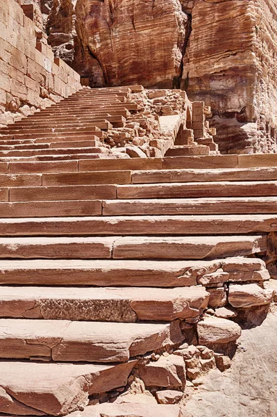 A long series of red sandstone steps leads to the Urn Tomb in the Royal Tombs area of Petra in Jordan.