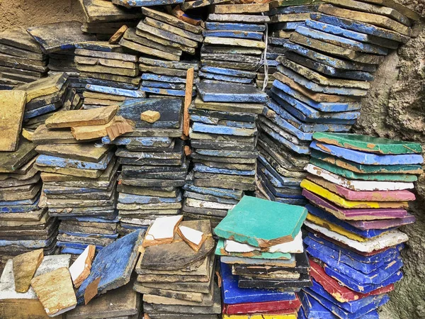 Parlak renkli kiremit yığını bir seramik fabrikasında bir fırın dışında renkleri pişirmeye ateş etti sonra yığılı.