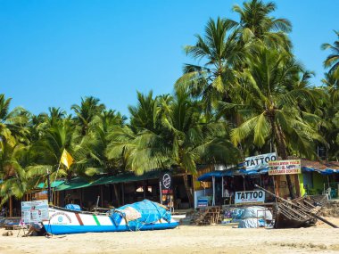 Goa, Hindistan 22 Şubat 2011: Tropikal palmiye ağaçları, bungalov ve sokak hayatı Palolem Beach'te, Güney Goa, Hindistan. Seyahat ve Turizm kavramı