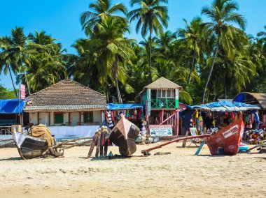 Goa, Hindistan 22 Şubat 2011: Balıkçı tekneleri, tropikal palmiye ağaçları, bungalovlar ve sokak hayatı Palolem Beach'te, Güney Goa, Hindistan. Seyahat ve Turizm kavramı