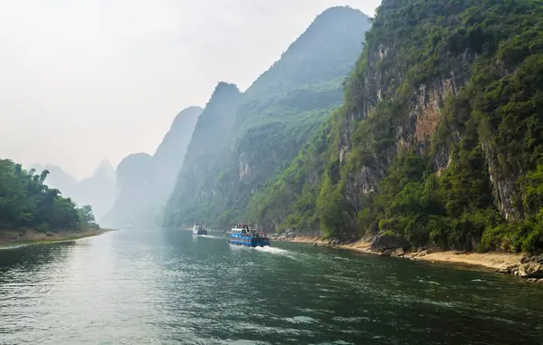 Xingping, Çin - 20 Ekim 2013: Turist tekneleri ile muhteşem manzaralı rota Li Nehri boyunca Guilin Yangshuo kara sevdanın seyahat turistler.