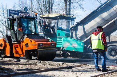 Kiev, Ukrayna, Mart, 2017: Asfalt kaplama, parke yol silindirleri taze asfalt yolun Rusanovka bölgesinde tüm genişliği üzerinden sıkıştırma çalışır. Kiev, Ukrayna