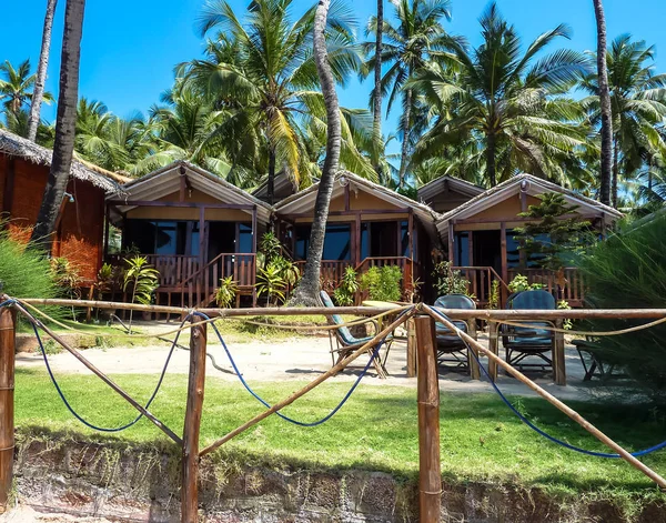 在椰子树和明亮的蓝天 帕洛林海滩的背景下 关闭单层木制平房 旅游和旅游理念 — 图库照片