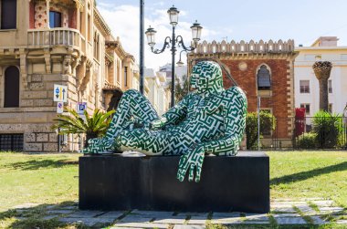 Reggio Calabria, Italy - October 30, 2017: Modern sculpture of artist Paola Epifani (Rabarama) and Neo-gothic style villa Genoese-Zerbi, Reggio Calabria, southern Italy clipart
