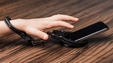 Belgili tanımlık smartphone küçük bir çocuk elinde kelepçeli. bir sembol teknoloji kötüye. Yüksek çözünürlük.