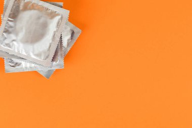 Prezervatif turuncu bir arka plan üzerinde.