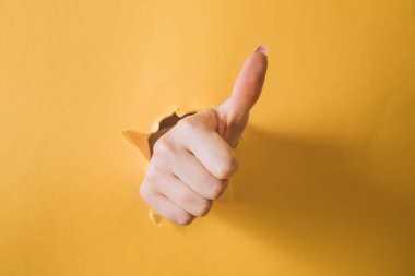 kız el sarı kağıt keser ve bir jest gösterir.