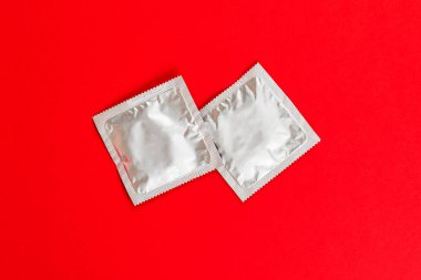 Prezervatif kırmızı bir arka plan üzerinde.