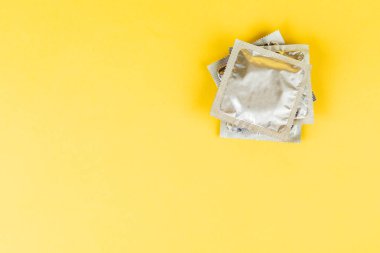 Prezervatif sarı bir arka plan üzerinde.
