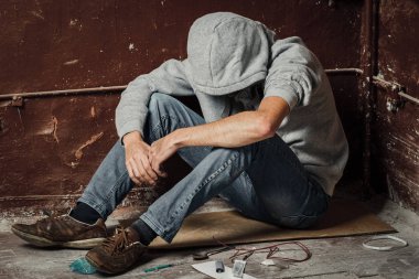Yerde yatarken uyuşturucu kullanan bir şırınga uyuşturucu bağımlısı bir adamdır. Anti ilaçları kavramı. erkek uyuşturucu bağımlısı, ilaç şırınga.