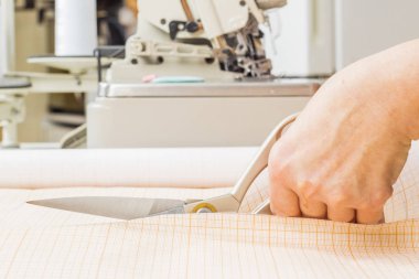 çalışan dikiş üretim için kumaş kesme Makası kullanır. Dikiş üretim hattı.