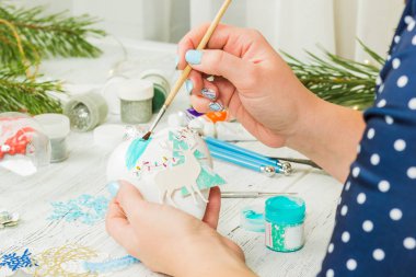 Noel süsleri, toplar, oyuncak ve hediye kutuları eski bir ahşap panosuna. Eller Noel süsleri yapmak.