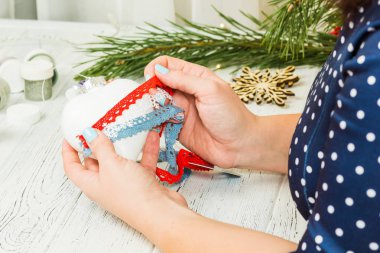 Noel süsleri, toplar, oyuncak ve hediye kutuları eski bir ahşap panosuna. Eller Noel süsleri yapmak.