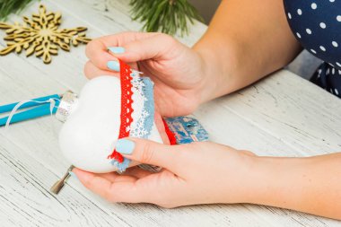 Noel süsleri, toplar, oyuncak ve hediye kutuları eski bir ahşap panosuna. Eller Noel süsleri yapmak.