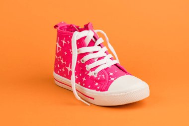 Kırmızı çocuk ayakkabıları. Turuncu zemin üzerine