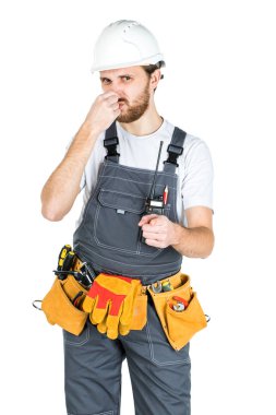 Bir inşaatçı ya da koruyucu kasklı bir çalışan burnu kötü kokudan korur. Beyaz arka plan üzerinde yalıtılmış