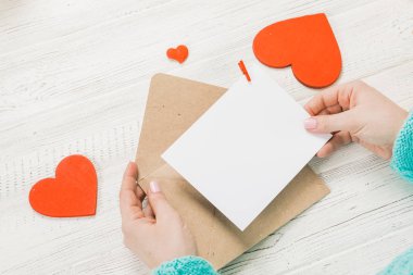 Kızın Saint Sevgililer günü aşk mektubu yazma el. El yapımı kart kırmızı kalp şeklinde rakam ile. 14 Şubat tatil kutlaması. Sevgililer günü kavramı kopya alanı ile.