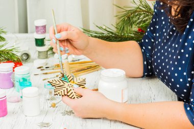 Noel süsleri, toplar, oyuncak ve hediye kutuları eski bir ahşap panosuna. Eller Noel süsleri yapmak.