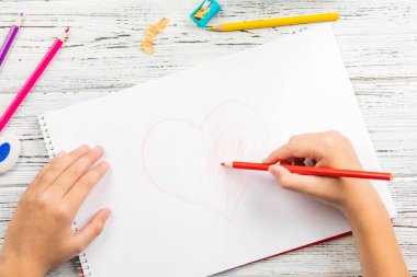 Kırmızı kalp ahşap masa üzerinde white paper renkli kalemle çizim çocuklar kontrolden