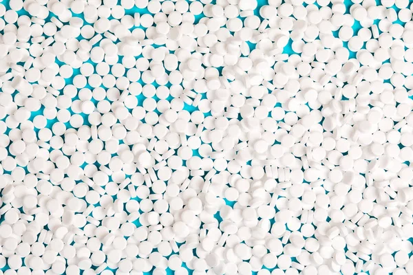 Sugar pills blue background. Medical pills close-up.