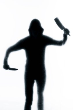Elinde bir bıçak ile buzlu cam arkasında tehlikeli bir adam. Cadılar Bayramı. Siyah beyaz resim
