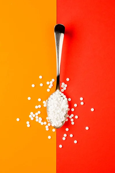 糖取代片剂勺在橙色和红色背景 — 图库照片