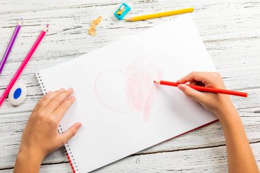 Kırmızı kalp ahşap masa üzerinde white paper renkli kalemle çizim çocuklar kontrolden