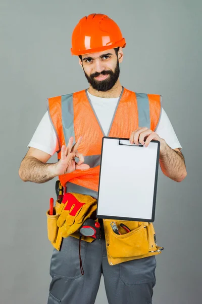 Builder Orange Helmet Gray Background Signs Something — Stock Photo, Image