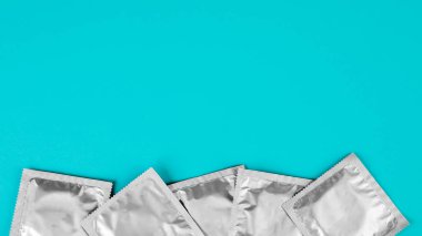 Mavi arka planda prezervatif. Güvenli seks kavramı