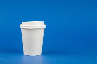 Kağıt kahve kap mavi zemin üzerine beyaz kapaklı. Take-away içecek kapsayıcı. İçki Kupası şablonu tasarımınız için.