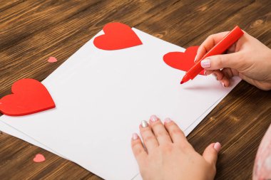 Kız bir kırmızı, küçük fırça, koyu arka plan kalbinde boyar. Tüm sevenler, Sevgililer günü için hazırlanıyor. arka plan resmi