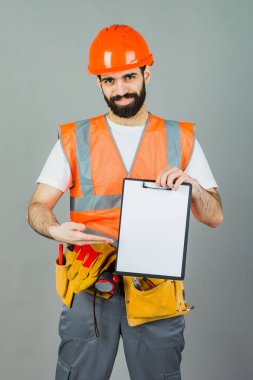 Turuncu bir kask gri bir arka plan üzerinde bir üreticisi bir şey işaretleri.