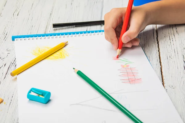 Kids drawing and lots of pencils for drawing on wooden background