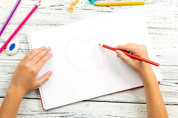 Kırmızı kalp ahşap masa üzerinde white paper renkli kalemle çizim çocuklar kontrolden