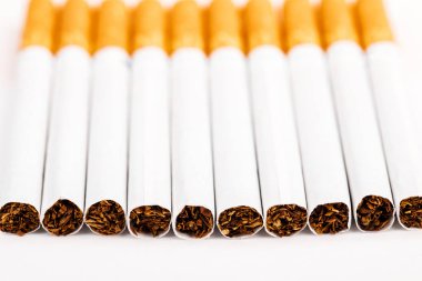 Beyaz arka planda tütün sigaralarının yakın çekim.