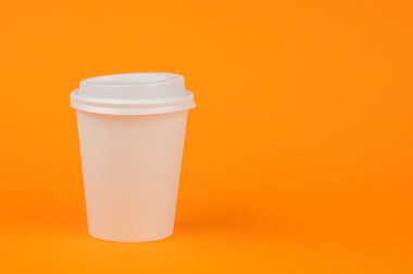Turuncu bir backgro üzerinde beyaz bir kapak ile kahve için kağıt konteyner