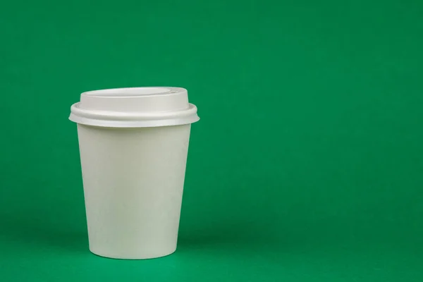 Paper coffee container with white lid on green background. Bever — Stock Photo, Image