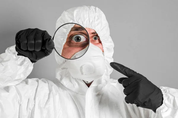 Scientist in protective clothing, glasses and respirator looks t — Stock Photo, Image