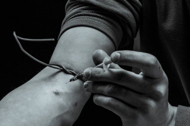 Bir insana elinde bir aşı enjekte edilir. Uyuşturucu kavramı. Hastalık kavramı. Şırınga kullanan bir uyuşturucu bağımlısı uyuşturucu kullanıyor..