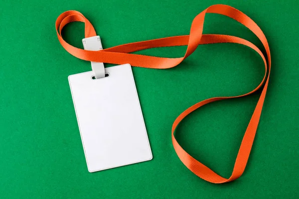 Etiqueta de seguridad en blanco con un cuello de franja roja sobre un fondo verde . — Foto de Stock