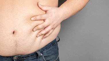 şişman adam, onun ağırlığı kontrol, gri bir arka plan üzerinde