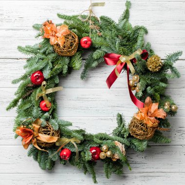 Beyaz ahşap arka plan üzerinde süsler ile Noel çelenk.