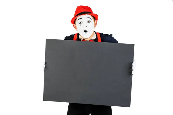 Fröhlicher Künstler mim hält eine schwarze Tafel auf weißem Hintergrund — Stockfoto