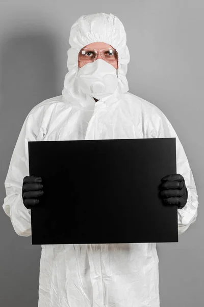 A medical scientist or policeman in protective clothing holds an — Stock Photo, Image